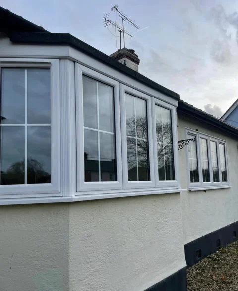 White bay and casement windows with Georgian bars on a rendered bungalow