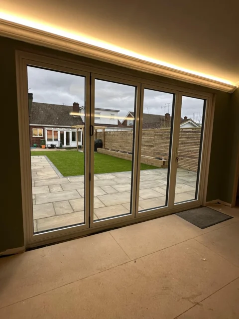 The same garden-room opening with the white interior faces of the bi-fold doors closed.