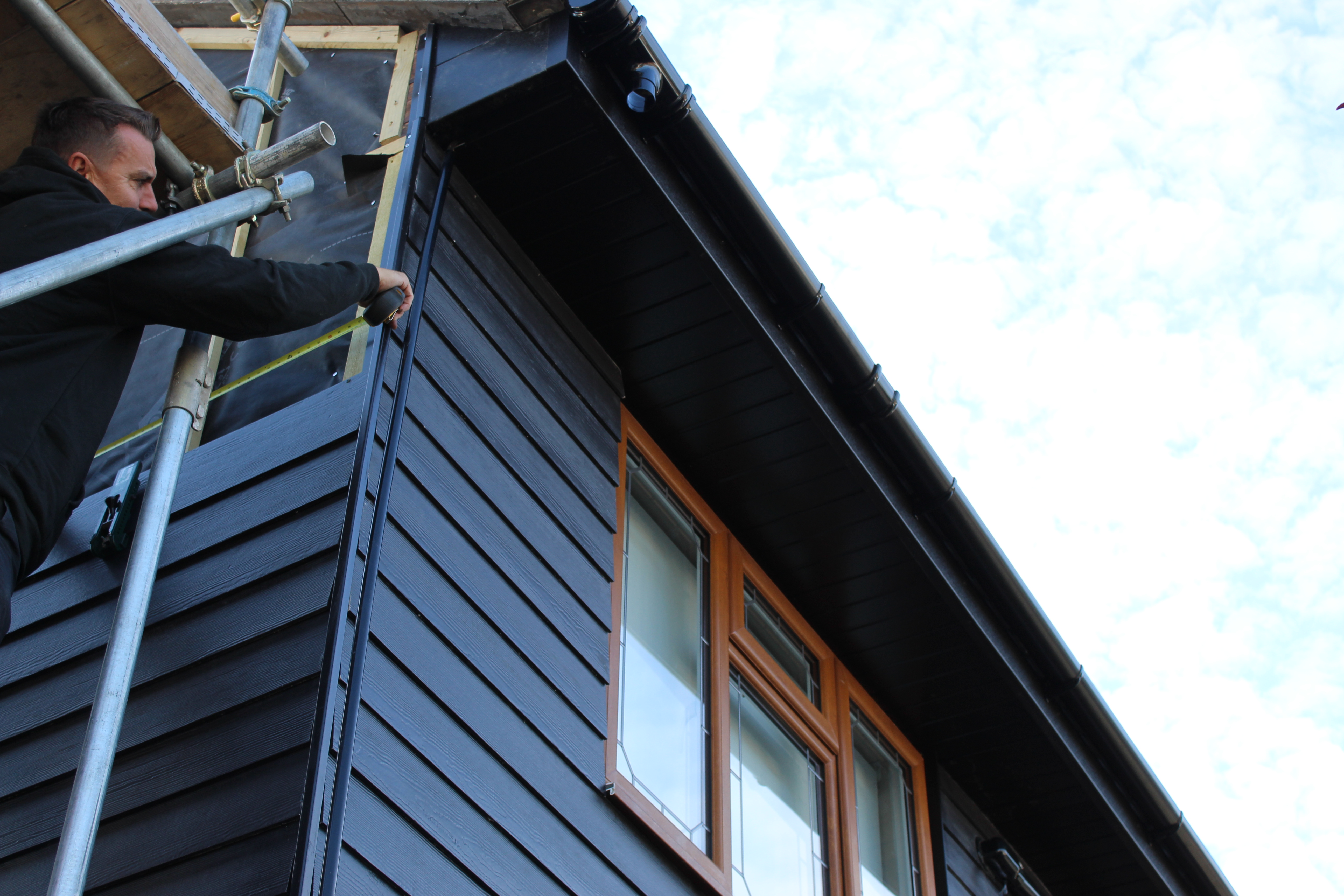Installer measuring dark external cladding