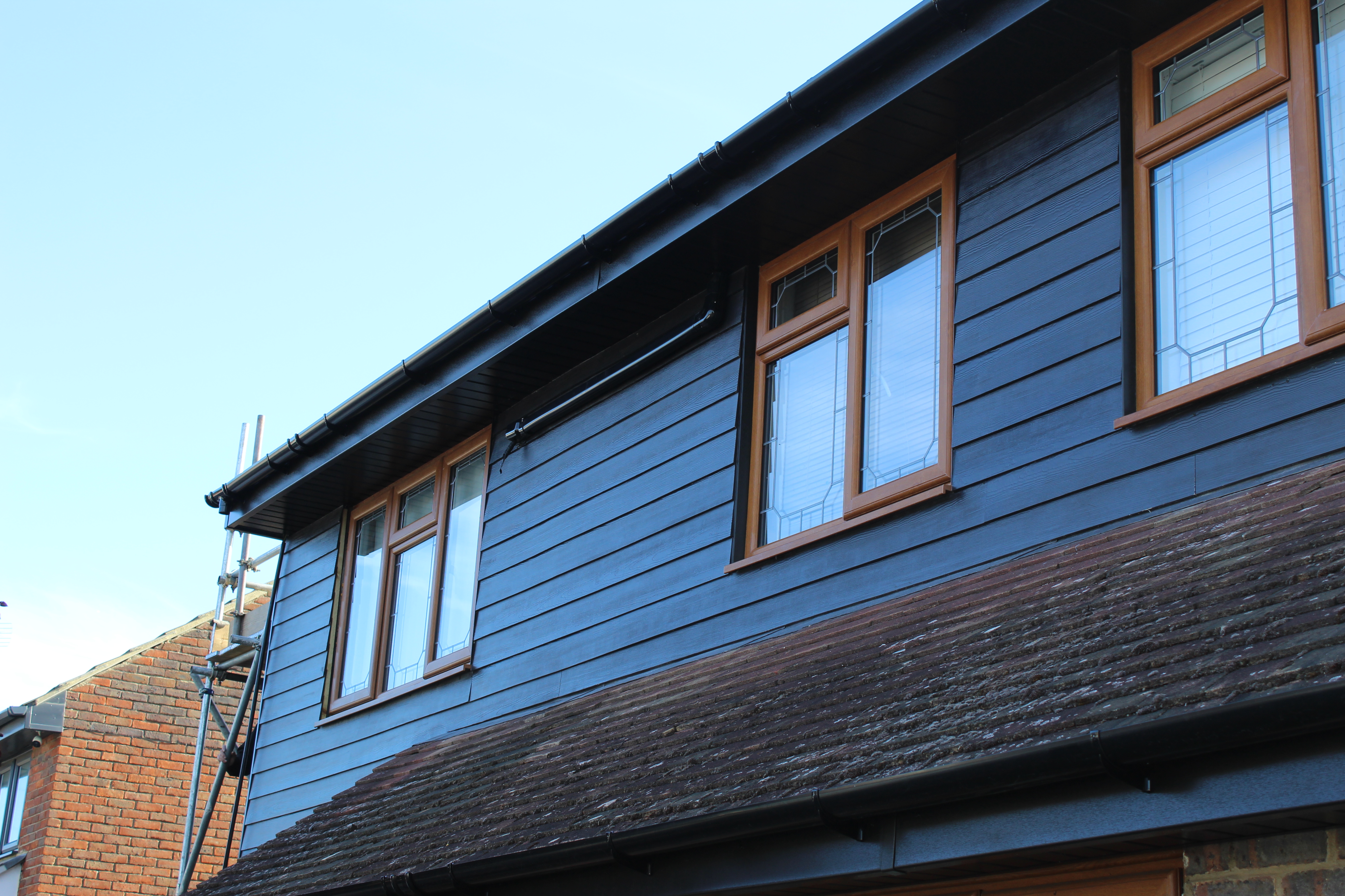 Dark horizontal cladding with timber-effect windows