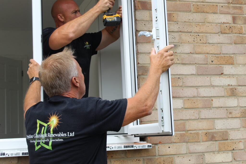 Two Pristine installers fitting a window to a brick home