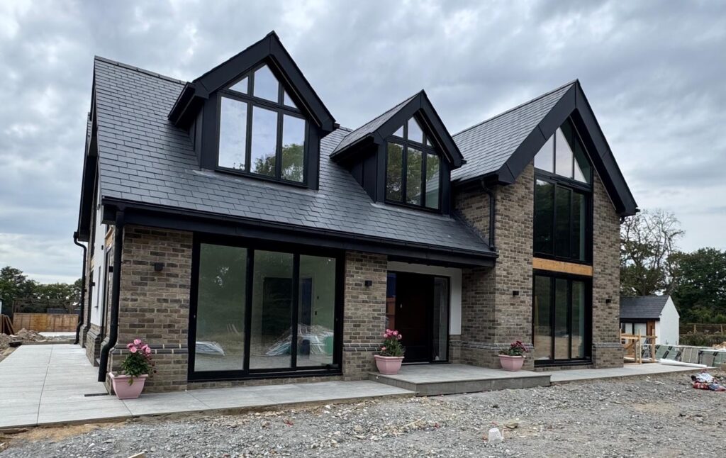 Home Modern house with dark-framed windows and full-height glazed doors