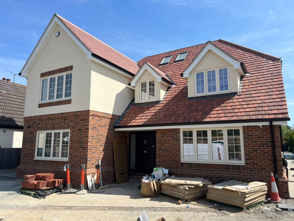 Home Front of a house with cream window frames and a tiled roof