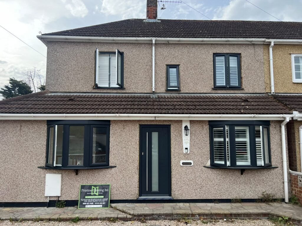 Home House with dark window frames, a bay window and a matching front door