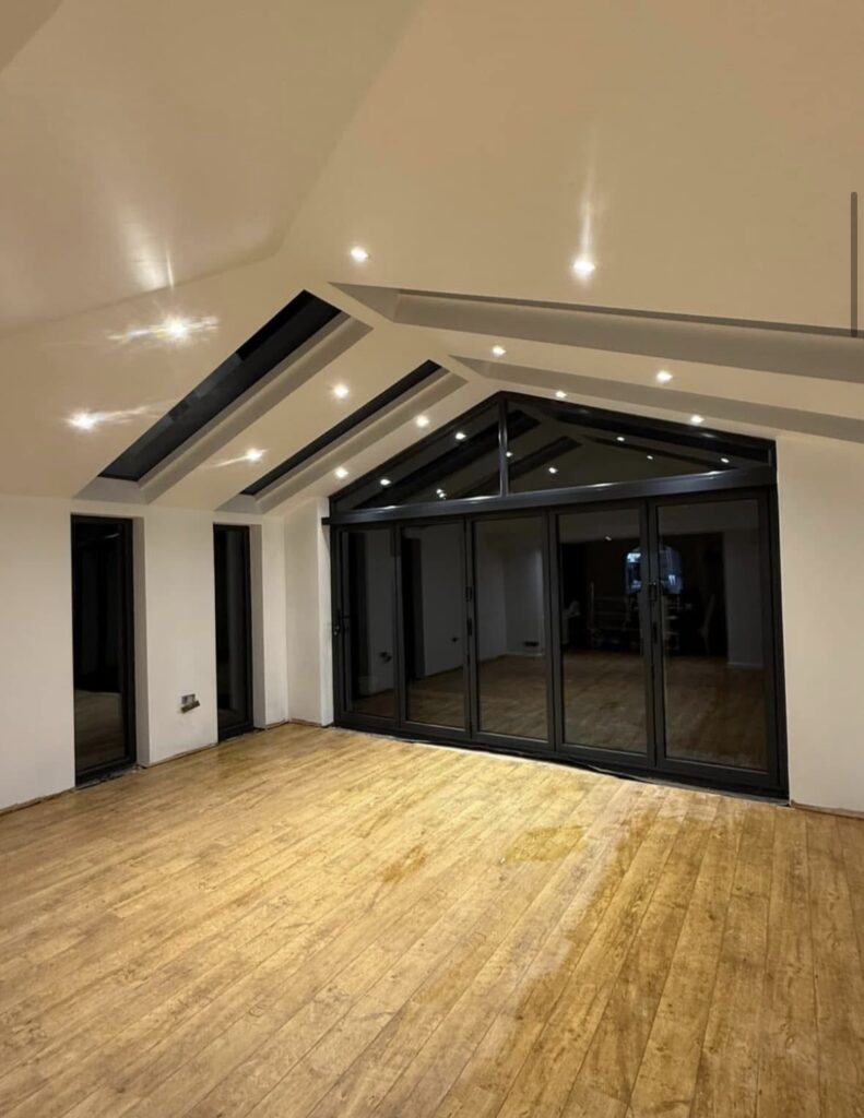 Home Vaulted room with dark-framed glazing and doors at the gable end